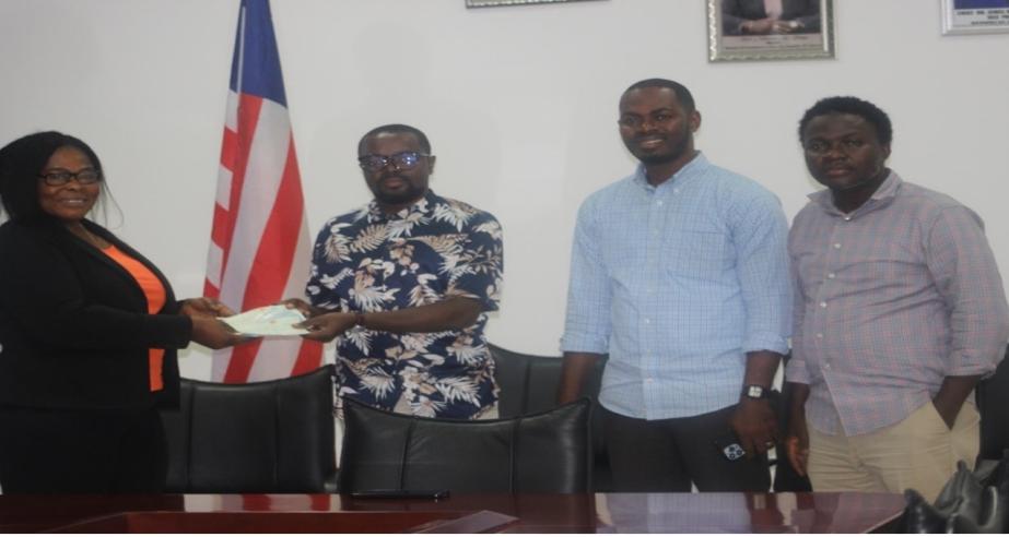Deputy Commerce Min./Adm. Wilfred Bangura presenting the checks 