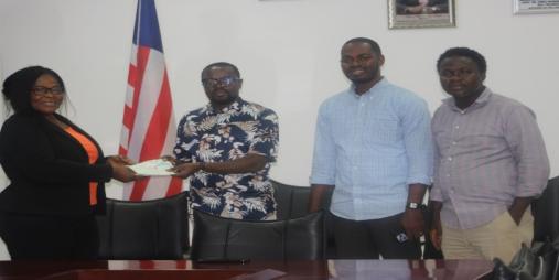 Deputy Commerce Min./Adm. Wilfred Bangura presenting the checks 