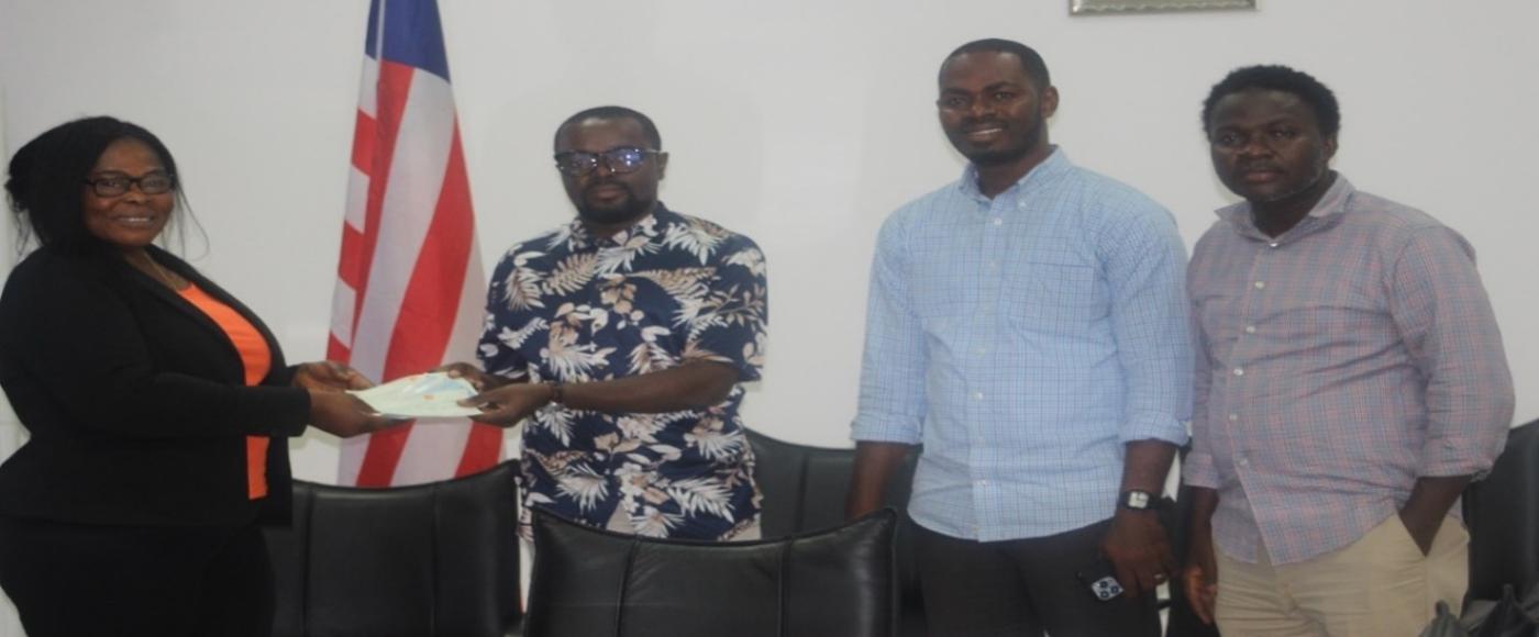 Deputy Commerce Min./Adm. Wilfred Bangura presenting the checks 